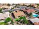 Aerial view of a home showcasing a putting green, desert landscaping, covered patio, and a sparkling pool at 2605 Orchid Valley Dr, Las Vegas, NV 89134