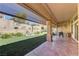 A covered back patio features a concrete floor, sunshades, and an outdoor space with artificial turf at 2605 Orchid Valley Dr, Las Vegas, NV 89134