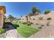 Well-maintained backyard with a putting green, desert landscaping, and a charming brick walkway at 2605 Orchid Valley Dr, Las Vegas, NV 89134