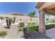 The backyard features desert landscaping, including small trees and privacy walls for seclusion at 2605 Orchid Valley Dr, Las Vegas, NV 89134