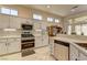 Well-lit kitchen featuring white cabinets, stainless steel appliances, and beautiful countertops at 2605 Orchid Valley Dr, Las Vegas, NV 89134