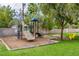 Community playground with slide, climbing structures, and a charming yellow chair surrounded by trees at 3189 Montecito Dr, Las Vegas, NV 89120
