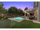 Serene backyard featuring a sparkling pool, putting green, and covered patio area with comfortable seating at 364 Trentino Alto St, Henderson, NV 89012