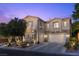 Charming two-story home featuring a stucco exterior, stone accents, and a well-maintained landscape at dusk at 364 Trentino Alto St, Henderson, NV 89012