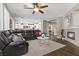 Spacious living room with a modern fireplace, a ceiling fan, and views to the kitchen at 364 Trentino Alto St, Henderson, NV 89012