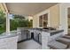Well-equipped outdoor kitchen featuring stainless steel appliances, a built-in grill, and stylish stone accents at 364 Trentino Alto St, Henderson, NV 89012