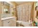Bathroom featuring single sink vanity, and a shower/tub combo with neutral tile surround at 3877 Platis Cir, Las Vegas, NV 89103