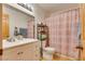 Bathroom featuring a toilet, shower with patterned curtain, and a white vanity with chrome faucet at 3877 Platis Cir, Las Vegas, NV 89103