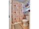 Cozy bathroom featuring a toilet, shower with patterned curtain, and decorative shelving unit at 3877 Platis Cir, Las Vegas, NV 89103