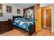 Bedroom with hardwood floors, a mural, black furniture, and ensuite access at 3877 Platis Cir, Las Vegas, NV 89103