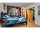 Bedroom with hardwood floors, a mural, mirror closet doors, and ensuite access at 3877 Platis Cir, Las Vegas, NV 89103