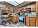Open kitchen with wood cabinets, granite countertops, stainless appliances, and view of the Gathering room at 3877 Platis Cir, Las Vegas, NV 89103