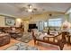 Open living room features hardwood floors, a ceiling fan, and multiple couches for relaxing at 3877 Platis Cir, Las Vegas, NV 89103