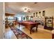 Spacious living room with a pool table, adjacent to the kitchen and features a brick fireplace at 3877 Platis Cir, Las Vegas, NV 89103