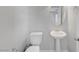 Bright bathroom with a pedestal sink, toilet, and a mirrored cabinet at 3908 Total Eclipse St, Las Vegas, NV 89129