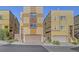Modern three-story homes with two-car garages, and landscaped front yards under a blue sky at 3908 Total Eclipse St, Las Vegas, NV 89129