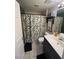 Well-lit bathroom with a plant-themed shower curtain and updated vanity at 3975 N Hualapai Way # 246, Las Vegas, NV 89129