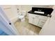 Bright bathroom with tiled floors, a white vanity with a black countertop, and a toilet next to the tub at 4238 Boratko St, Las Vegas, NV 89115