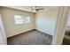 This bedroom features plush gray carpeting, a ceiling fan, and a window at 4238 Boratko St, Las Vegas, NV 89115