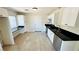 Updated kitchen with black countertops, stainless steel appliances, and tile flooring at 4238 Boratko St, Las Vegas, NV 89115