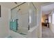 Bathroom featuring a tub and shower combination with glass doors and view of the hallway at 5415 W Harmon Ave # 2075, Las Vegas, NV 89103