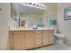 Bright bathroom featuring a dual sink vanity, a large mirror and a toilet at 5415 W Harmon Ave # 2075, Las Vegas, NV 89103