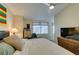 Bedroom featuring a queen size bed, side table, and a wall mounted TV with a ceiling fan at 5415 W Harmon Ave # 2075, Las Vegas, NV 89103