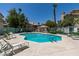 Community pool with lounge chairs surrounded by mature trees and landscaping at 5415 W Harmon Ave # 2075, Las Vegas, NV 89103