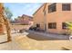 Backyard featuring gravel and brick-paved areas, mature trees, and outdoor dining set, enhancing outdoor living at 5917 Horsehair Blanket Dr, North Las Vegas, NV 89081