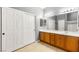 Bathroom boasts double doors, a vanity with wooden cabinets, and tile floors at 5917 Horsehair Blanket Dr, North Las Vegas, NV 89081
