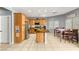 Well lit kitchen with tile floors, wood cabinets, and a dining table at 5917 Horsehair Blanket Dr, North Las Vegas, NV 89081