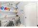 Laundry room with stainless steel washer and dryer, storage shelving, and convenient access to the laundry room closet at 5917 Horsehair Blanket Dr, North Las Vegas, NV 89081