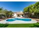 Inviting backyard with a freeform pool, spa, and lush landscaping, perfect for outdoor entertaining at 6126 Bedrock Ct, North Las Vegas, NV 89031