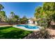 Enjoy this backyard featuring a pool, lush green lawn, and landscaped surroundings at 6126 Bedrock Ct, North Las Vegas, NV 89031