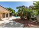 Beautiful backyard showcasing a pool, lush landscaping, and ample patio space for entertaining at 6126 Bedrock Ct, North Las Vegas, NV 89031
