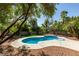 Inviting backyard pool with mature trees, colorful landscaping, and ample lounge space at 6126 Bedrock Ct, North Las Vegas, NV 89031