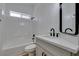 Well-lit bathroom with a shower-tub combo, white tiling, and a modern vanity with sleek fixtures at 6126 Bedrock Ct, North Las Vegas, NV 89031