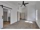 Bedroom featuring a barn door leading to a bathroom, vaulted ceiling, and neutral carpet at 6126 Bedrock Ct, North Las Vegas, NV 89031
