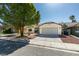 Well-kept single-story home with desert landscaping, a two-car garage, and a welcoming entrance at 6126 Bedrock Ct, North Las Vegas, NV 89031