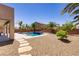 Beautiful backyard with a pool, palm trees, gravel landscaping and a stone walkway to the house at 6489 Crest Estates St, Las Vegas, NV 89131