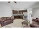 Open floor plan with a living room and kitchen featuring granite counters, stainless appliances, and dark wood cabinets at 6489 Crest Estates St, Las Vegas, NV 89131