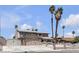 Two-story home featuring a driveway, two palm trees, a front yard, and secure fencing at 6628 Celeste Ave, Las Vegas, NV 89107