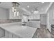 Bright kitchen with white cabinetry, stone backsplash, modern pendant lights, and marble floors at 6628 Celeste Ave, Las Vegas, NV 89107