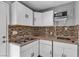 This compact kitchen features white cabinetry, stainless sink, and a gas cooktop at 6628 Celeste Ave, Las Vegas, NV 89107