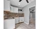 An efficient kitchen offers white cabinets, a microwave, and neutral-toned backsplash and flooring at 6628 Celeste Ave, Las Vegas, NV 89107