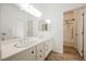 Bright bathroom featuring double sinks, a large mirror, and a separate shower and bathtub at 6808 Indian Chief Dr # 204, Las Vegas, NV 89130