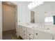 Well-lit bathroom with double sinks and a doorway leading to a walk-in closet at 6808 Indian Chief Dr # 204, Las Vegas, NV 89130
