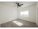 A minimalist bedroom featuring neutral carpet, ceiling fan, and a bright window at 6808 Indian Chief Dr # 204, Las Vegas, NV 89130
