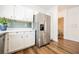 Kitchen view showcasing stainless steel refrigerator, white cabinets, and wood-look floors at 6808 Indian Chief Dr # 204, Las Vegas, NV 89130