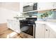 Beautiful kitchen boasts stainless steel stove and microwave, white cabinets, and green backsplash at 6808 Indian Chief Dr # 204, Las Vegas, NV 89130